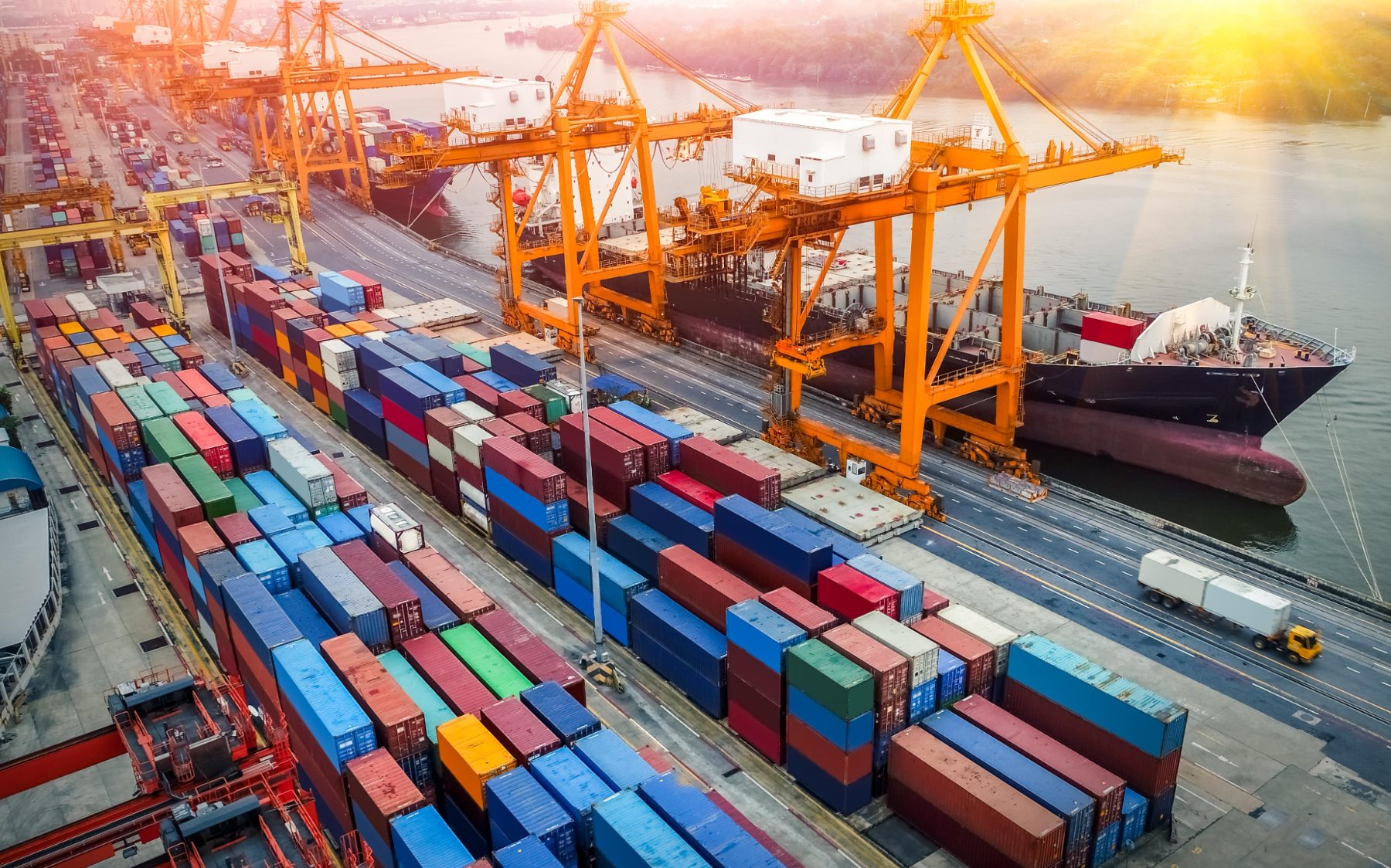 Container terminal with cranes working at sunset